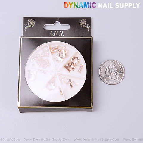A 26pcs rose gold AB rhinestone letter nail charm set is shown next to a U.S. quarter on a gray background.