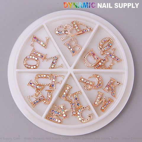 A round wheel holds 26 rose gold A-Z alphabet charms with AB rhinestones for dazzling nail art designs.