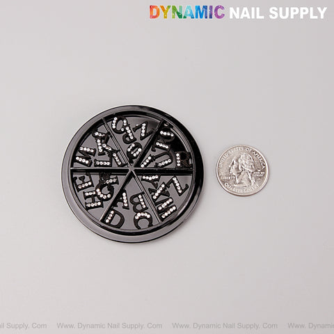 26pcs Black with Silver Rhinestone Letter Nail Charms A-Z shown next to a U.S. quarter for size comparison.