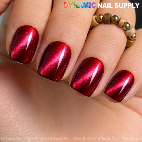 Short, square nails in Bordeaux Cat Eye #1 magnetic glassy red wine shimmer gel; beaded ring on the fingers.