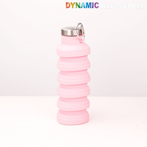 A Collapsible Silicone Lightweight Reusable Pink Bottle sits on a white surface; DYNAMIC NAIL SUPPLY is above.