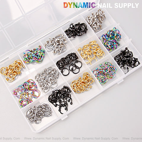 A box with gold, silver, titanium & black piercing nail charms for DIY punk Y2K nail art accessories and design.