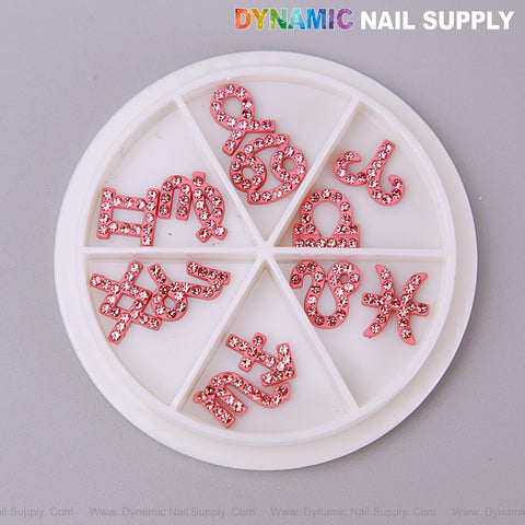 A round white wheel holds the Set of Pink Zodiac Symbol Sign Nails Charm with Rhinestone by DYNAMIC NAIL SUPPLY.