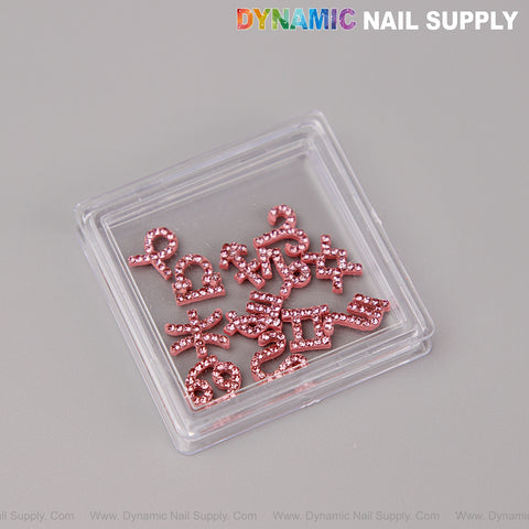 12 pcs Pink Rhinestone Zodiac Sign Charms—nail art gems by DYNAMIC NAIL SUPPLY on gray background.