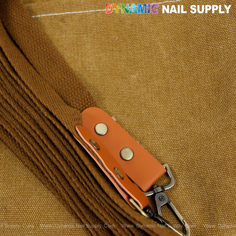 Close-up of the Unisex Professional Apron’s brown cotton canvas strap with leather accent and metal clasp on fabric.