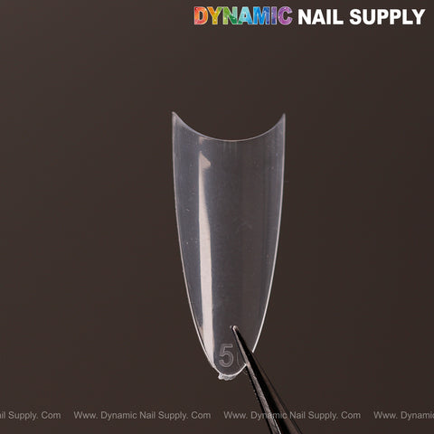 A clear, size 5 (Ultra Thin) Medium Almond Nail Tip is held by tweezers under DYNAMIC NAIL SUPPLY on a dark background.