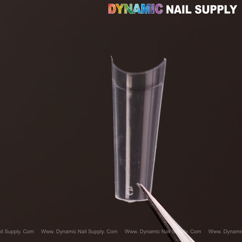 A Medium Coffin Nail Tip Half Cover is held by tweezers, with the Dynamic Nail Supply logo in the top right.