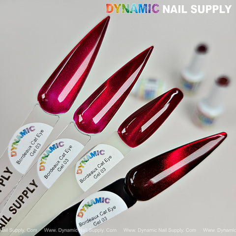 Four glossy red wine gel swatches—Bordeaux Cat Eye #3—Magnetic Glassy Shimmery Gel Polish, bottles in background.