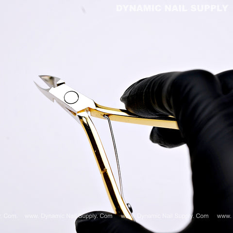 Hand in a black glove holding D555 Professional Cuticle Nippers with full jaw, high-tension spring on white background.