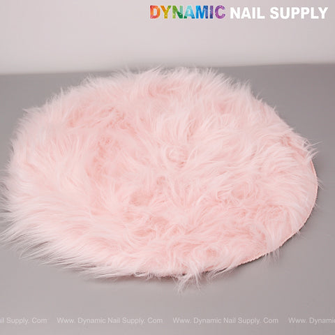 The Light Pink Faux Fur Fabrics Round Display Mat is shown on a gray surface under the Dynamic Nail Supply logo.
