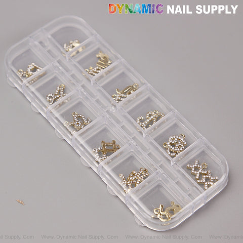 A clear box holds 24 gold and silver rhinestone zodiac nail art charms and accessories in separate compartments.