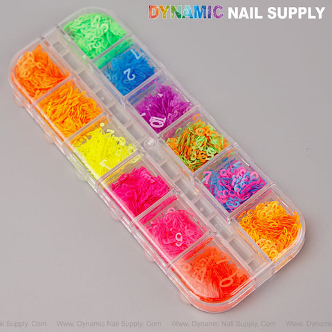 A clear plastic box holds Colorful Neon Nail Sequins Number Charms in vibrant neon shades for nail art.