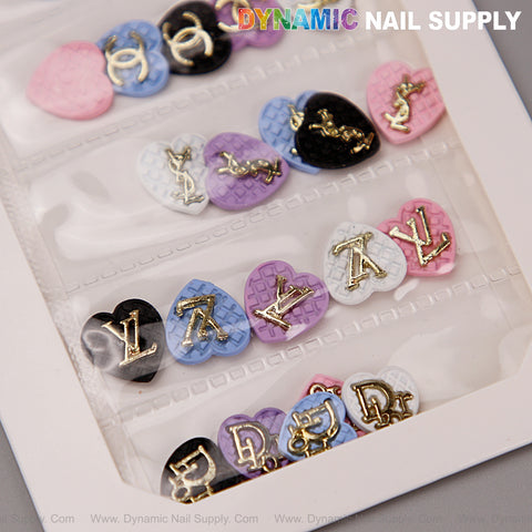 LV logo heart-shaped resin nail charms in black, white, pink, blue & purple for nail designs by Dynamic Nail Supply.