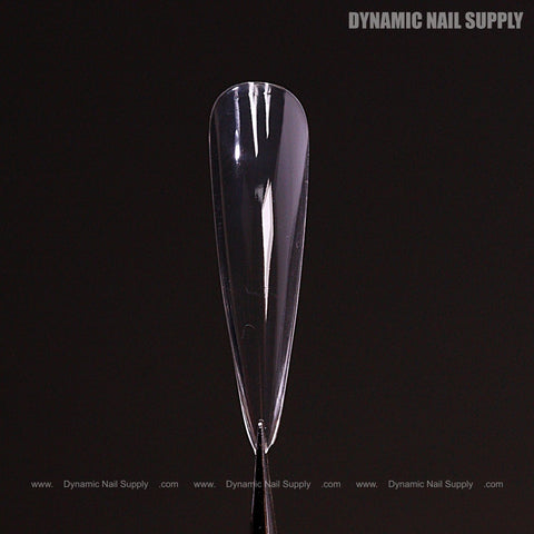 A clear Sculpted Stiletto XL Full Cover Soft-Gel Nail Tip stands vertically on a black background with branding.
