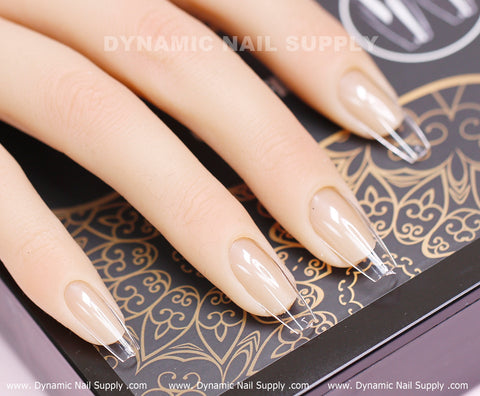 A hand with [Coffin M] Full Cover Tips - Soft Gel X tips (600 pcs) rests on a black and gold patterned surface.