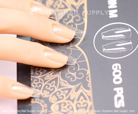A mannequin hand with Coffin M Full Cover Tips (600 pcs) rests on a black and gold decorative box.