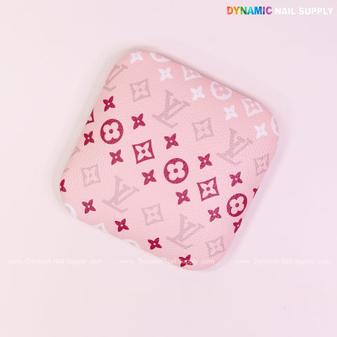 Soft pink elbow armrest for nail technicians with LV-style print; comfy, chic support for long hours.
