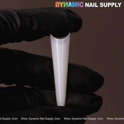 A gloved hand holds a Russia Almond Natural White Straight Half Cover Nail Tip against a dark background with product text above.