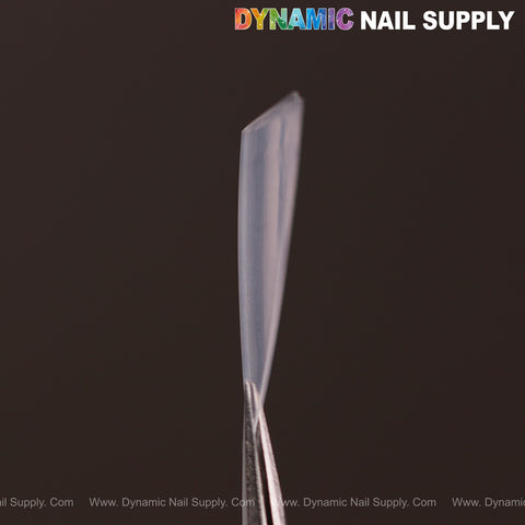 A close-up of (Ultra Thin) Medium Almond Extension Nail Tips held by tweezers, logo at top right.