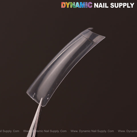 A clear XXL Duck Shape Nail Tip from the 440pcs box is held by tweezers on a dark background.