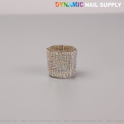 A rhinestone-covered nail drill bit next to an AB Rhinestone Small Cup Dappen Dish Liquid Container on a light surface.