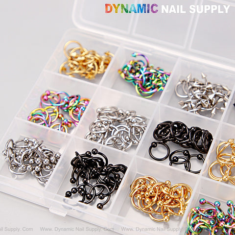 A box holds Gold Silver Titanium Black Piercing Nail Charms—Alloy Punk Set for nail art, DIY by Dynamic Nail Supply.