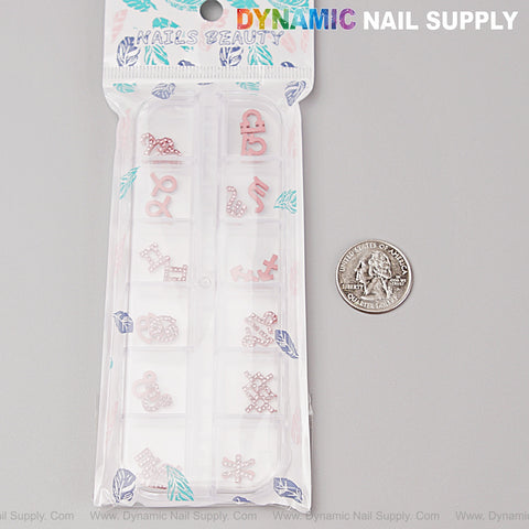 24 pink zodiac sign nail charms with rhinestones for DIY nail art, shown next to a quarter for scale.