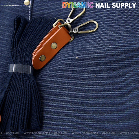 A cotton canvas unisex apron with oversized pockets, cross-back straps, and DYNAMIC NAIL SUPPLY text.