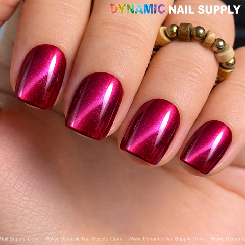 A hand with Bordeaux Cat Eye #6 shimmery gel polish and a beaded gold ring on the middle finger.