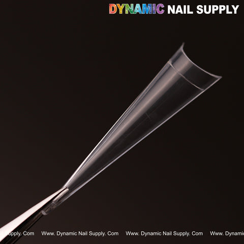 A clear XXL Sharp Stiletto Nail Tip held by tweezers, Dynamic Nail Supply at top right. Box of 500, 10 sizes.