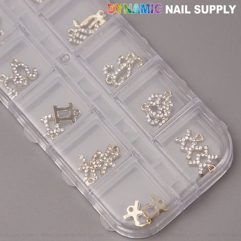 24 pcs Gold & Silver Rhinestone Zodiac Sign Charms—Twelve Constellation Nail Art DIY Design Accessories on gray surface.