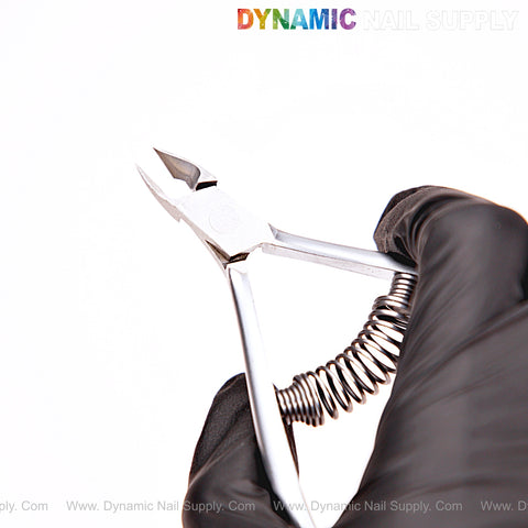 A gloved hand holds NT1217 - G02 5mm Professional Stainless Steel Cuticle Nippers against a white background.