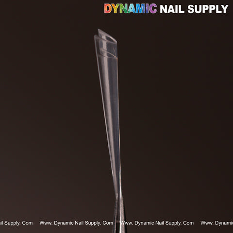 Two clear XXL Sharp Stiletto Nail Tips from the 500pc box set stand upright; DYNAMIC NAIL SUPPLY at the top.