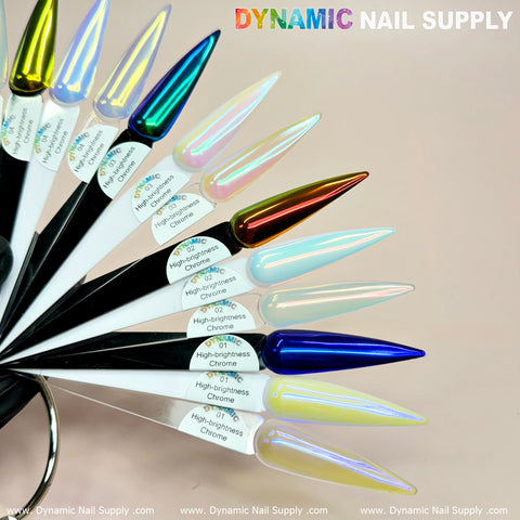 A circular arrangement of nail polish samples showcases a variety of colors, each one elongated, pointed, and marked with the label High-Brightness Chrome. The iridescent chrome powder gleams in hues of blue, green, yellow, red, and silver. Displaying Dynamic Nail Supply's branding in vibrant multicolored lettering crowns the design.