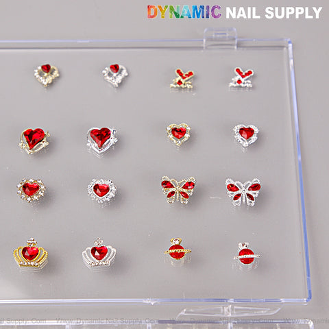 A clear box with 16 red, silver, and gold heart, cherry, crown, and planet nail art charms by DYNAMIC NAIL SUPPLY.