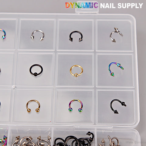 A clear box labeled DYNAMIC NAIL SUPPLY with gold, silver, titanium & black piercing nail charms for DIY nail art.