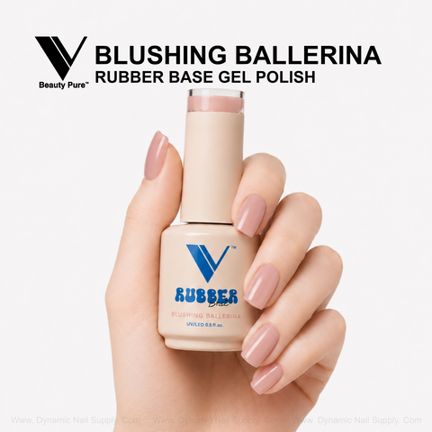 A hand with manicured ballet pink nails holds a bottle of V Beauty Pure Blushing Ballerina Rubber Base Gel Polish.