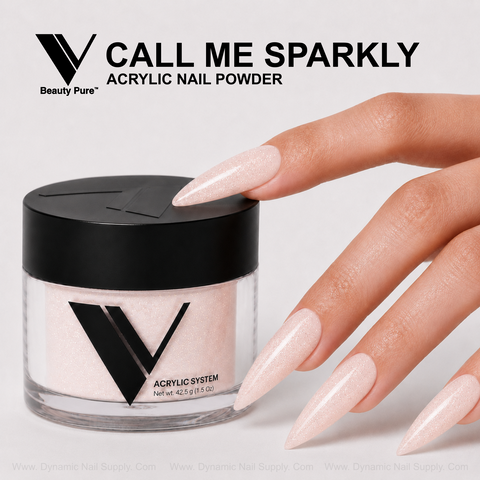 Long, sparkly nude nails touch a Call Me Sparkly - V Beauty Pure Acrylic Powder jar on a light background.
