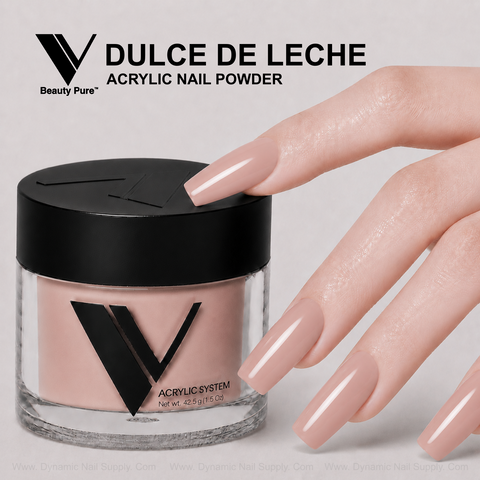 A hand with long nude-pink nails is beside V Beauty Pure - Dulce De Leche Acrylic Powder for flawless enhancements.