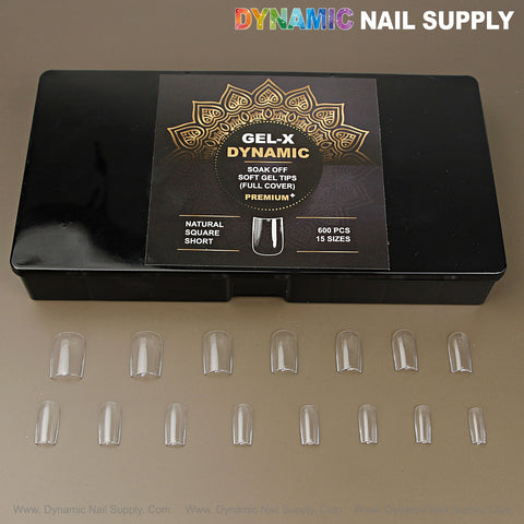 A black box labeled Natural Square (Short) with 15 full-cover nail tips on display on a brown surface.
