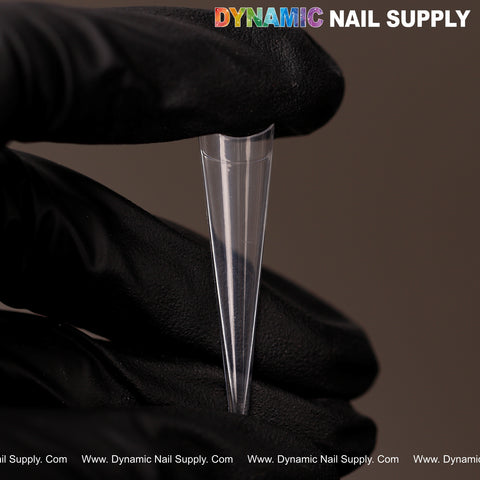 A gloved hand holds a clear XXL Sharp Stiletto Nail Tip; DYNAMIC NAIL SUPPLY logo appears at top right.