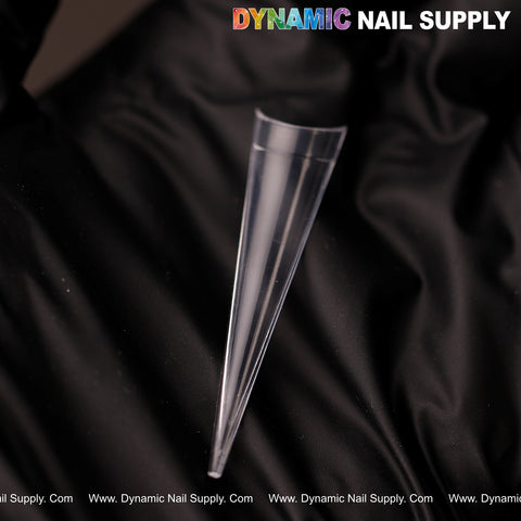 A clear XXL Sharp Stiletto Nail Tip lies on black fabric; XXL Sharp Stiletto Nail Tips Extension text at top right.