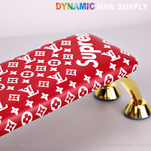Red 5upreme Pattern Handrest Armrest [R-A043] for manicure/pedicure with gold legs and DYNAMIC NAIL SUPPLY text.