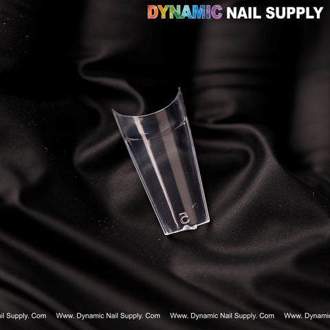 A clear nail tip labeled 2 rests on black satin, showcasing New Short Coffin Half Cover Tips—600 pcs, 12 sizes.