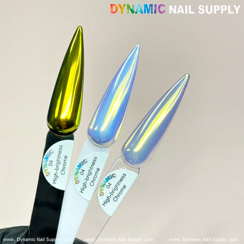 Three long, stiletto-shaped nail tips are showcased. The left nail sparkles in Bright-gold from Dynamic Nail Supply, while the two on the right glisten with Mermaid Iridescent Chrome #04 in light blue and purple hues. Each tip is labeled as High brightness Fine Pigment Powder, ideal for avant-garde nail art against a plain backdrop.