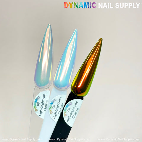 Three elongated, pointed nail samples are displayed vertically. From left to right, they showcase high-brightness chrome finishes with stunning pigment in iridescent white, light blue, and metallic bronze. Each is labeled by Dynamic Nail Supply using the Orange/Gold/Mermaid Iridescent Chrome #06 - High Brightness Fine Pigment Powder. The backdrop features a light neutral color.