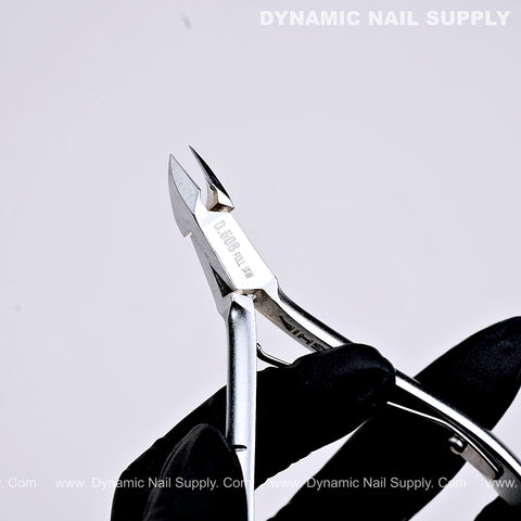 A gloved hand holds the D506 Professional Carbon Steel Cuticle Nippers against a plain white background.