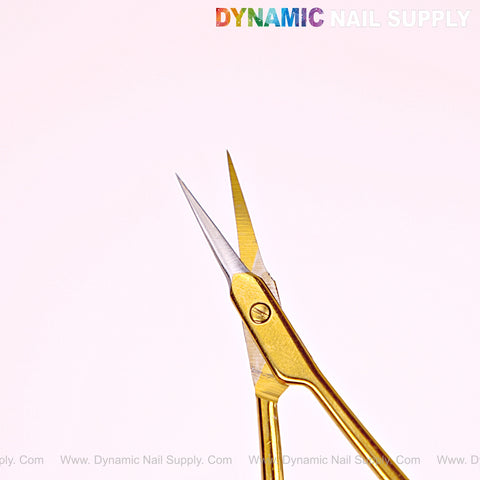 NT1245 Gold Premium Curved Tip Cuticle Scissors with stainless steel blades on a pale pink background.