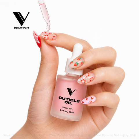 A hand with strawberry nail art holds V Beauty Pure - Strawberry Cuticle Oil for your next nourishing nail treatment.