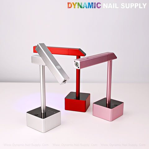 Three 2 in 1 Mini UV/LED Flash Cure Lamps in red, pink, and silver are displayed on stands against a white background.